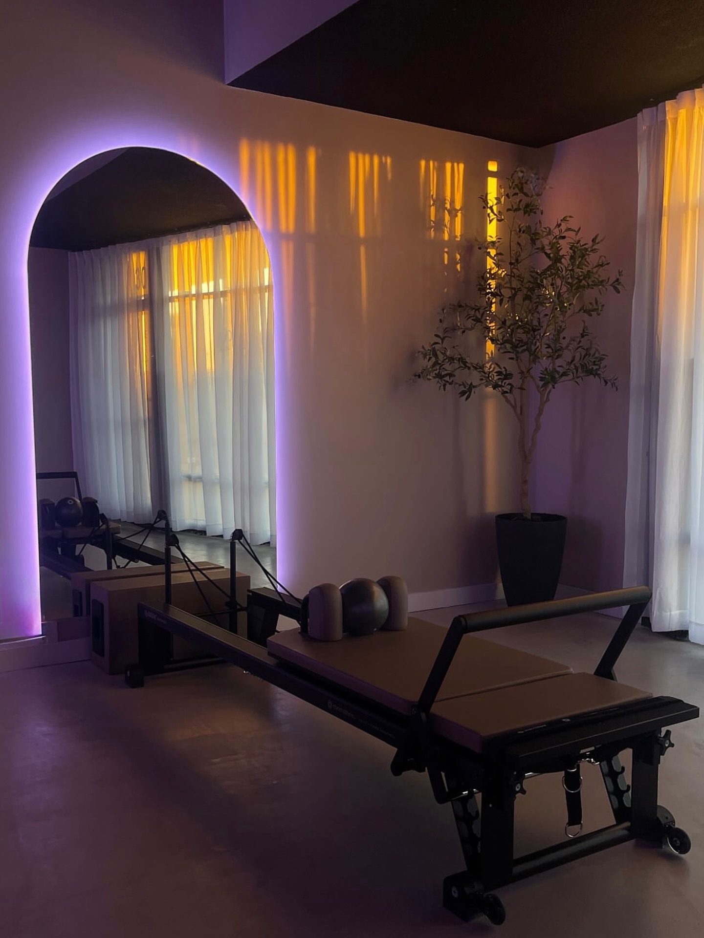An arched alcove inside the studio with a single reformer set to one side, lit warmly.