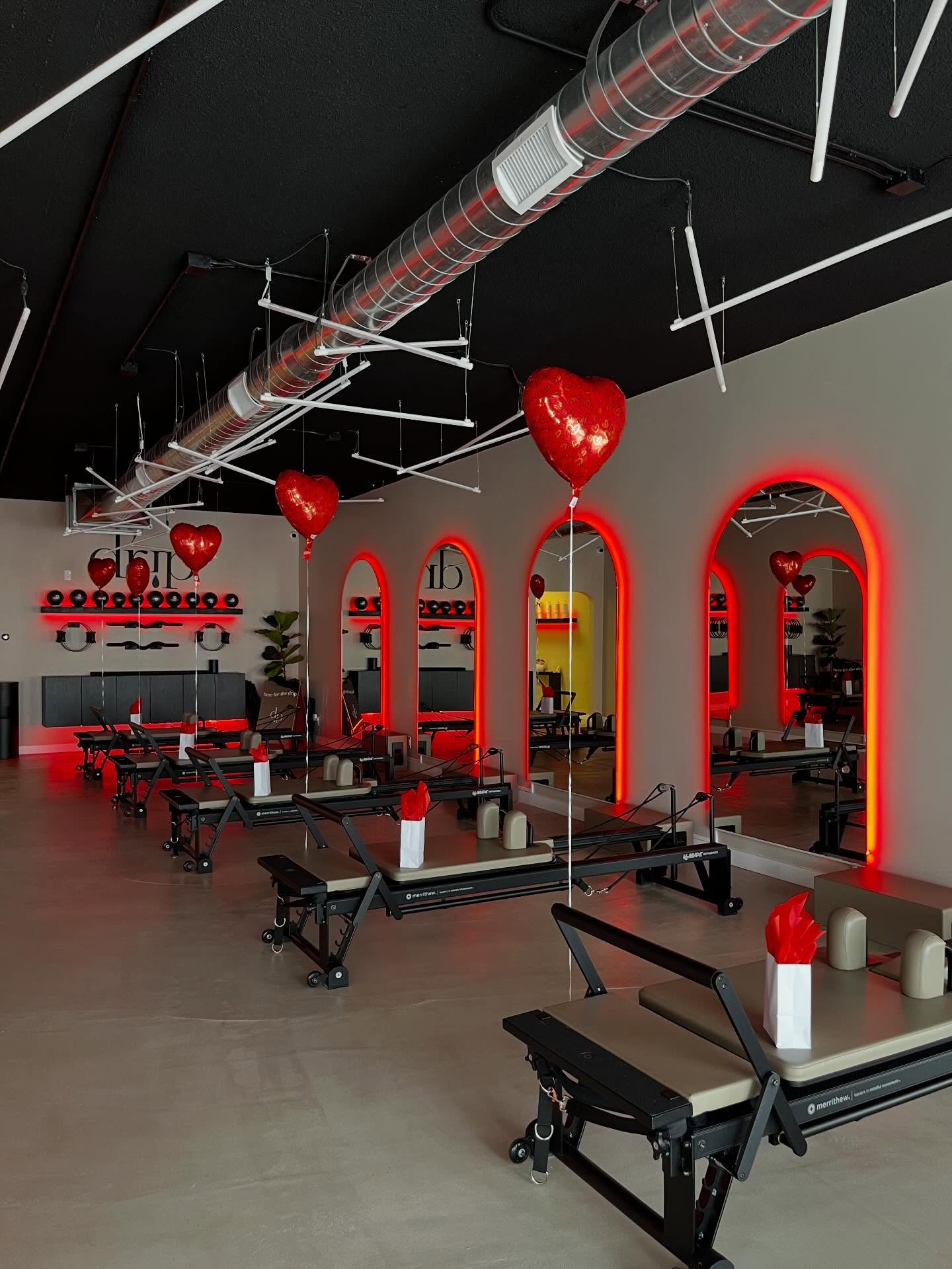 Wide view of the Drip Pilates studio with rows of reformers running between mirrored archways.